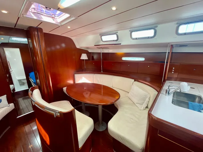 Caravan Yacht Photos Pics Luxurious interior of 2002 Beneteau First 47.7 yacht with elegant wood finish and cozy seating.