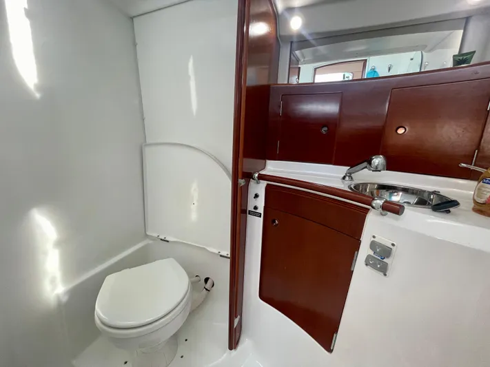 Caravan Yacht Photos Pics Bathroom interior of 2002 Beneteau First 47.7 yacht with wooden cabinetry and compact design.