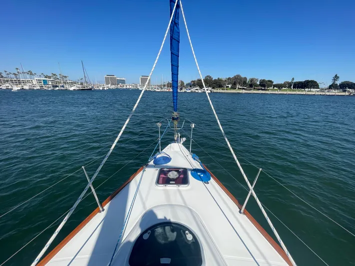 Caravan Yacht Photos Pics Bow view of 2002 Beneteau First 47.7 sailboat on calm water near marina.