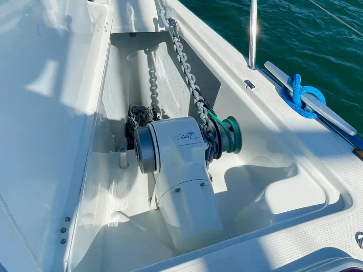 Caravan Yacht Photos Pics Anchor windlass on 2002 Beneteau First 47.7 sailboat deck, with chain and blue rope.