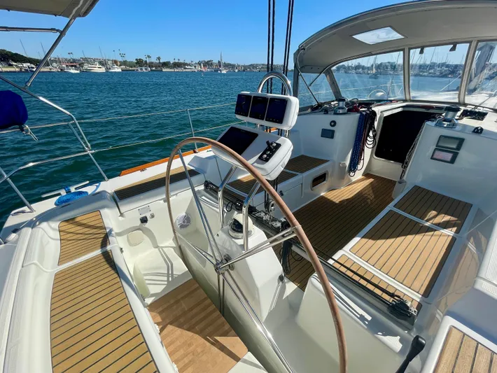 Caravan Yacht Photos Pics Cockpit of 2002 Beneteau First 47.7 sailboat with wooden deck and steering wheel.