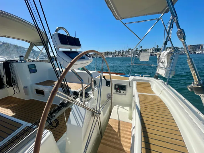 Caravan Yacht Photos Pics Beneteau First 47.7 sailboat cockpit with wooden deck, marina view, sunny day, 2002 model.