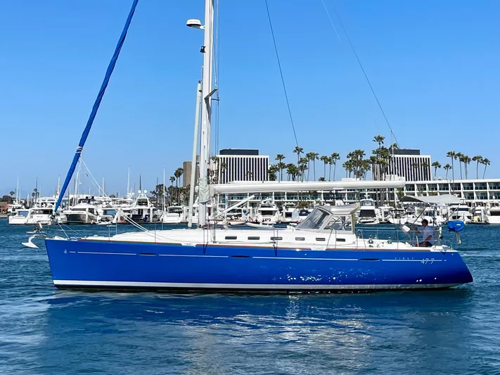 Caravan Yacht Photos Pics 2002 Beneteau First 47.7 sailboat with blue hull in a marina setting.