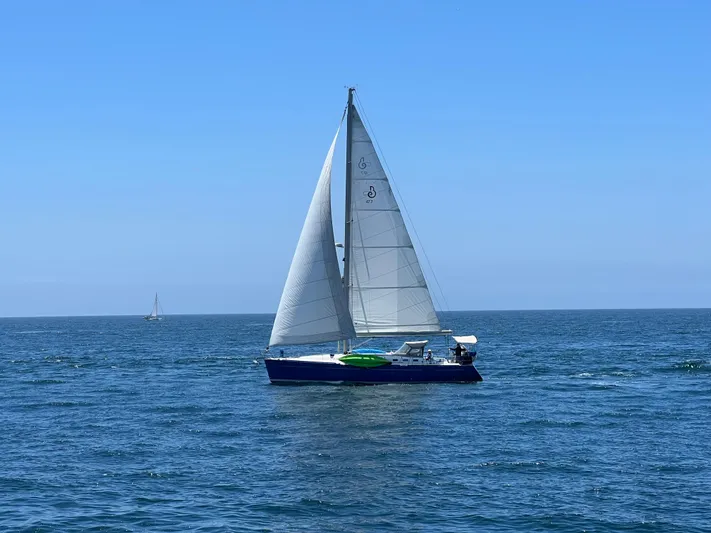Caravan Yacht Photos Pics Sailing yacht Beneteau First 47.7, 2002 model, cruising on open sea under clear blue sky.
