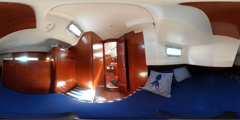 Caravan Yacht Photos Pics Interior of 2002 Beneteau First 47.7 yacht, featuring wooden cabinetry and cozy sleeping area.