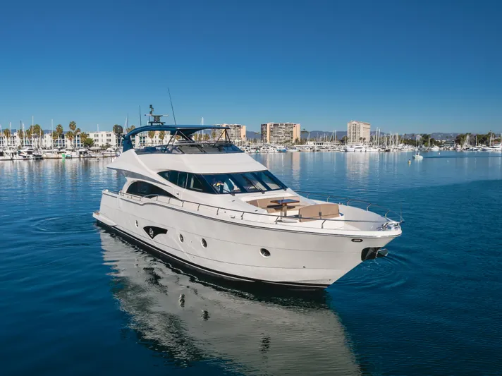 Fine Seas-onings Yacht Photos Pics Luxury 2018 Marquis 720 Fly yacht cruising in a serene marina setting.