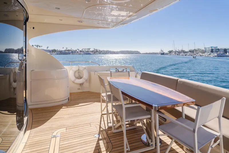 Fine Seas-onings Yacht Photos Pics Luxurious 2018 Marquis 720 Fly yacht deck with seating, overlooking serene waters and marina.