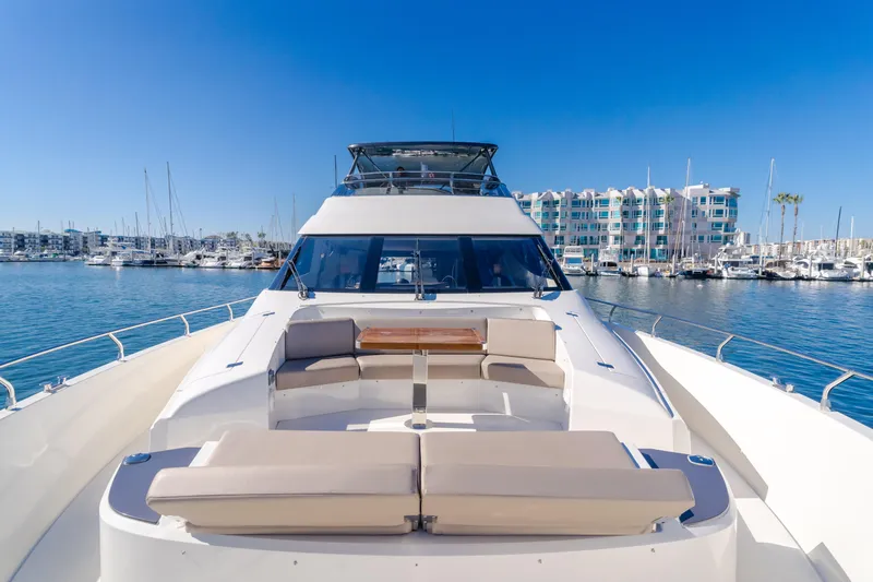 Fine Seas-onings Yacht Photos Pics 2018 Marquis 720 Fly yacht with spacious deck, docked in marina under clear blue sky.