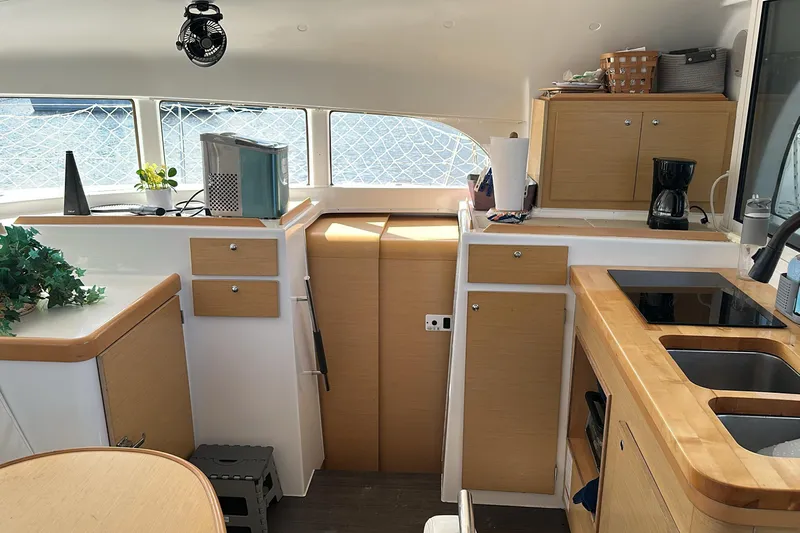 Alice Yacht Photos Pics Interior of 2015 Lagoon 380 S2 catamaran kitchen with modern appliances and wooden cabinetry.