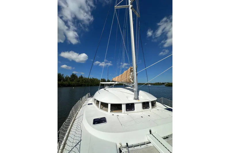 Alice Yacht Photos Pics 2015 Lagoon 380 S2 catamaran sailing on a calm river under a clear blue sky.