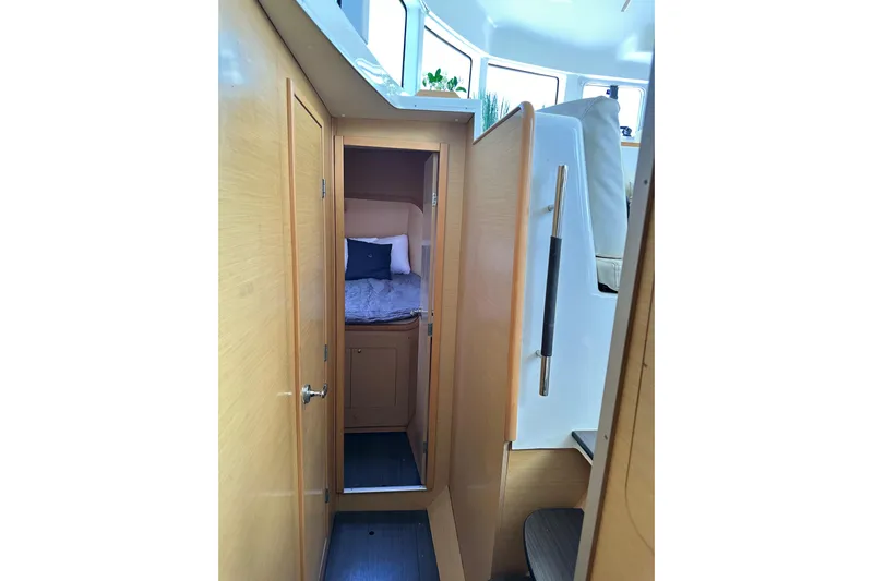 Alice Yacht Photos Pics Interior cabin of 2015 Lagoon 380 S2 catamaran, featuring cozy bed and wooden finish.