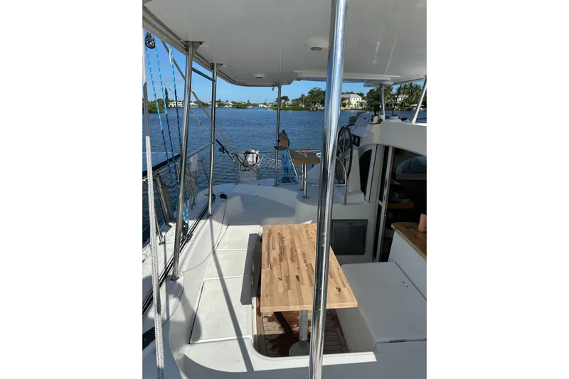 Alice Yacht Photos Pics 2015 Lagoon 380 S2 catamaran deck with wooden table, overlooking serene water.