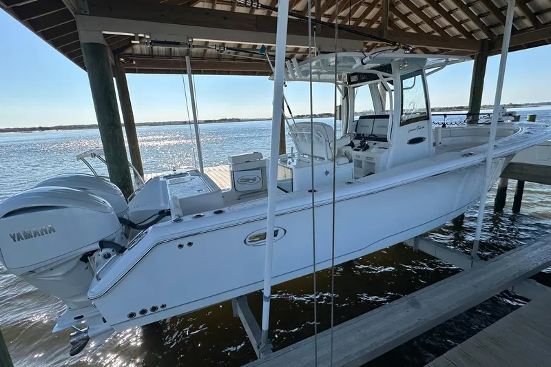 Yacht Photos Pics 2024 Sea Hunt Gamefish 30 Forward Seating boat docked under a wooden shelter.