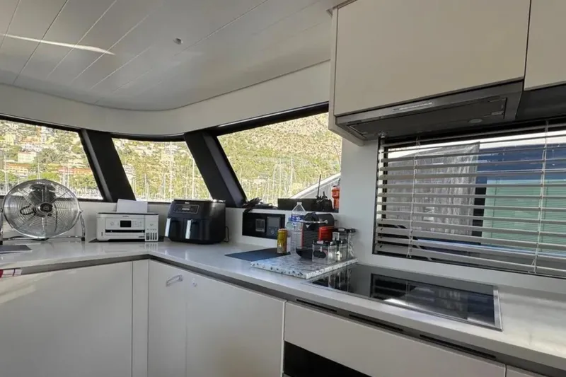  Yacht Photos Pics Modern kitchen interior of 2020 Bluegame BGX 70 yacht with appliances and large windows.