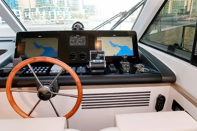 Azimut Magellano 60 Model 2025 Yacht Photos Pics Cockpit of 2025 Azimut Magellano 60 yacht with navigation screens and wooden steering wheel.