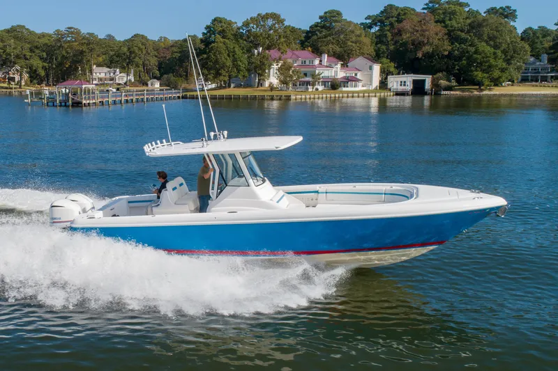 Ami Kids Donation Yacht Photos Pics 2015 Intrepid 327 Center Console boat cruising on a scenic lake.