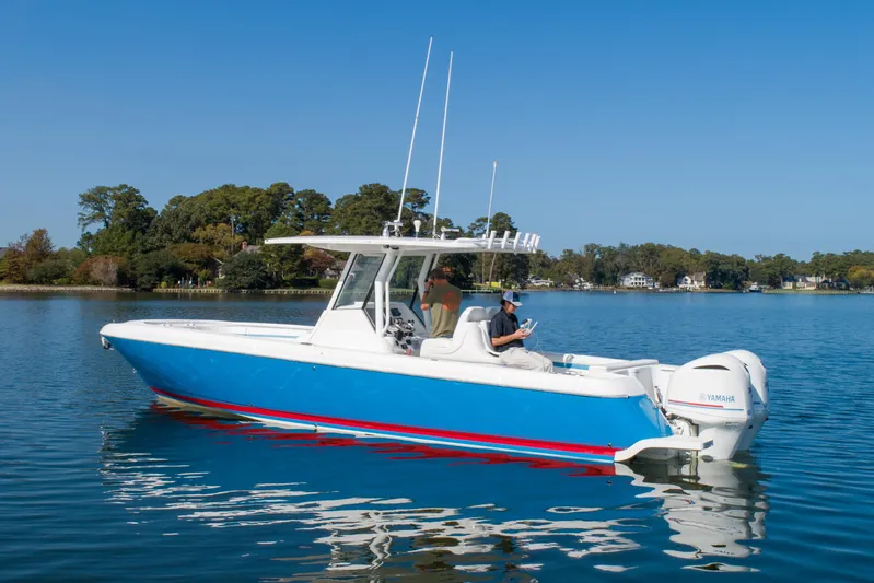 Ami Kids Donation Yacht Photos Pics 2015 Intrepid 327 Center Console boat on calm water, blue and white design.
