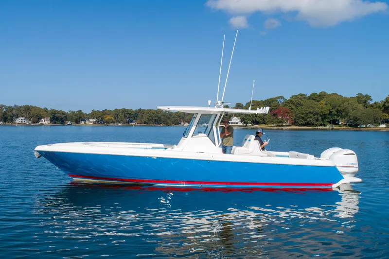 Ami Kids Donation Yacht Photos Pics 2015 Intrepid 327 Center Console boat on calm water, blue and white design.