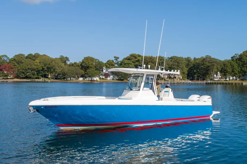 Ami Kids Donation Yacht Photos Pics 2015 Intrepid 327 Center Console boat on calm water, clear sky background.