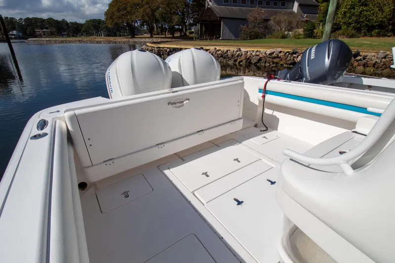Ami Kids Donation Yacht Photos Pics 2015 Intrepid 327 Center Console boat interior with dual engines, docked by a scenic shoreline.