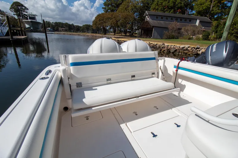 Ami Kids Donation Yacht Photos Pics 2015 Intrepid 327 Center Console boat with seating, docked by a scenic waterfront.