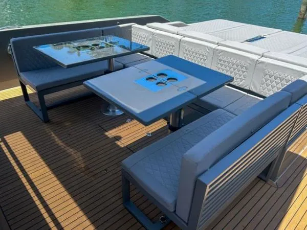 Yacht Photos Pics 2022 De Antonio Yachts D42 deck with modern seating and tables, overlooking water.