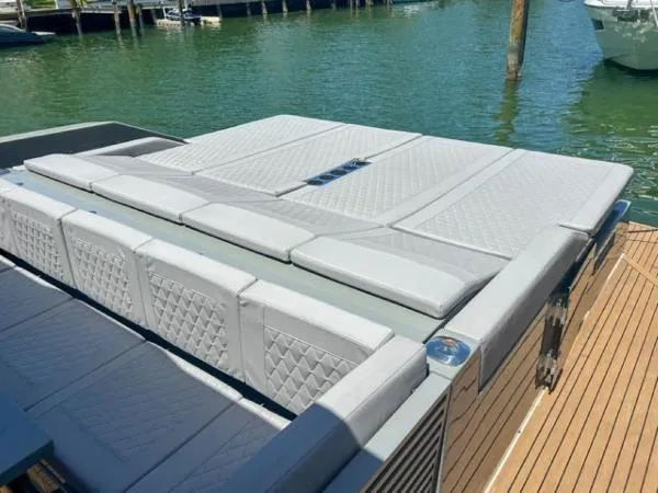  Yacht Photos Pics 2022 De Antonio Yachts D42 with elegant deck seating, docked on calm water.