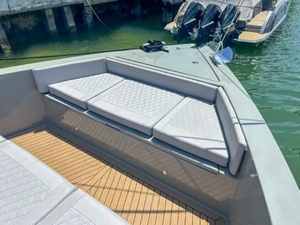  Yacht Photos Pics 2022 De Antonio Yachts D42 with cushioned seating and teak deck, docked by the water.