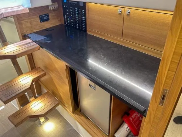  Yacht Photos Pics Interior of 2022 De Antonio Yachts D42, featuring a sleek kitchenette with wooden accents.