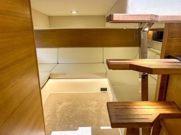  Yacht Photos Pics Interior of 2022 De Antonio Yachts D42, featuring wooden steps and cushioned seating area.