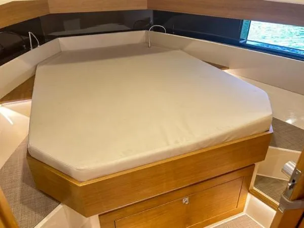  Yacht Photos Pics 2022 De Antonio Yachts D42 interior cabin with a comfortable bed and wooden accents.