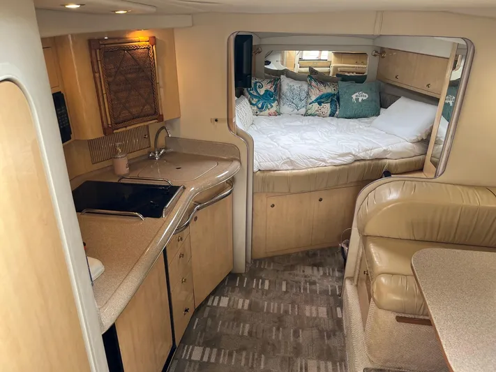 Tin Cup Yacht Photos Pics Interior of 2001 Sea Ray 340 Amberjack, featuring kitchen, seating, and cozy sleeping area.