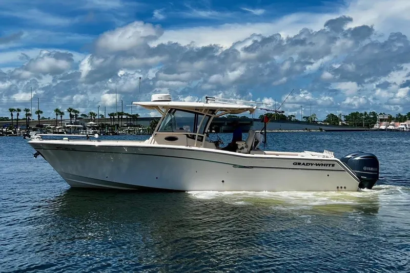  Yacht Photos Pics 2015 Grady-White Canyon 336 boat cruising on a sunny day with scenic backdrop.