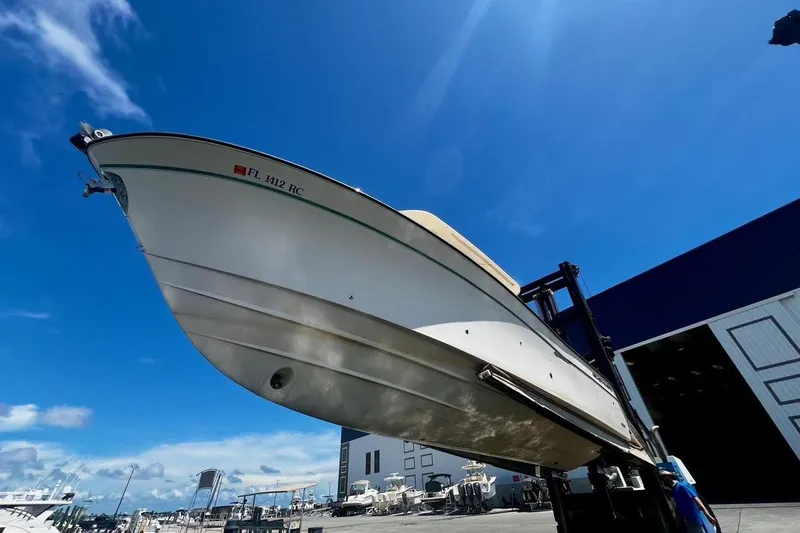  Yacht Photos Pics 2015 Grady-White Canyon 336 boat lifted at marina under clear blue sky.