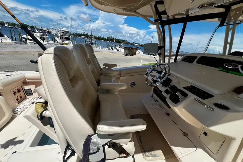  Yacht Photos Pics 2015 Grady-White Canyon 336 boat interior with helm and seating, docked by the marina.