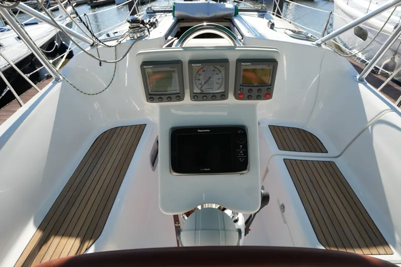 Andiamo! Yacht Photos Pics Cockpit of 2007 Beneteau 373 sailboat with navigation instruments and teak flooring.