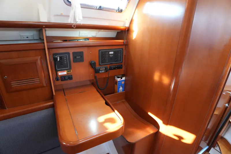 Andiamo! Yacht Photos Pics 2007 Beneteau 373 yacht interior with navigation station and wooden cabinetry.