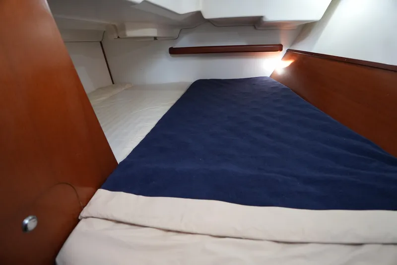 Andiamo! Yacht Photos Pics Cozy cabin interior of 2007 Beneteau 373 sailboat with blue bedding.