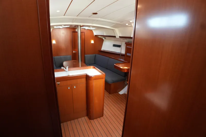 Andiamo! Yacht Photos Pics Interior of 2007 Beneteau 373 sailboat with wood finish and cozy seating area.