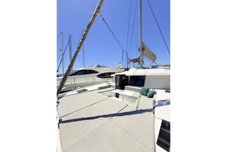 High School Yacht Photos Pics 2023 Bali 4.2 catamaran with spacious deck, docked at marina under clear blue sky.