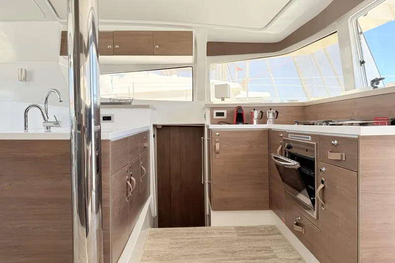 High School Yacht Photos Pics Modern kitchen interior on 2023 Bali 4.2 yacht with wood cabinets and stainless steel appliances.