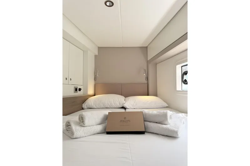 High School Yacht Photos Pics Cozy bedroom in 2023 Bali 4.2 yacht with neatly arranged towels and pillows.