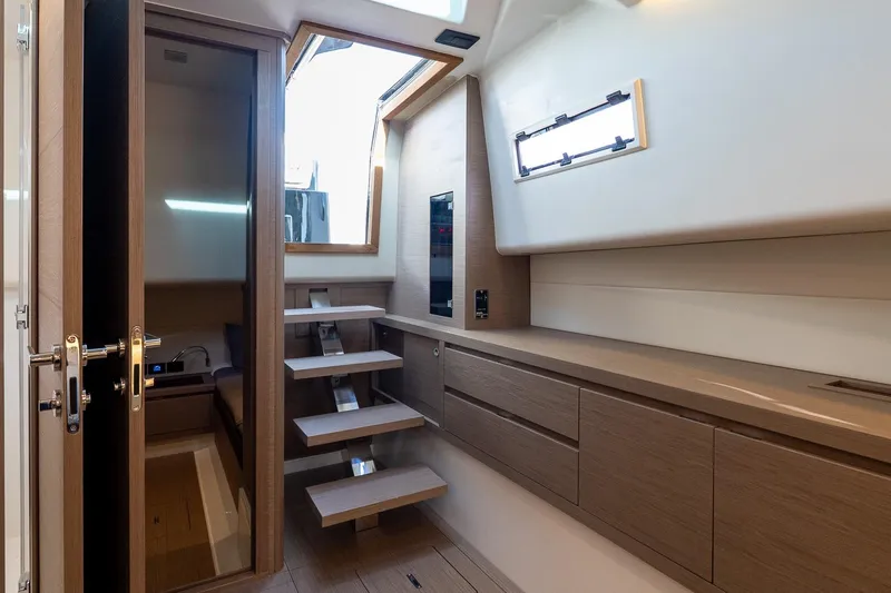  Yacht Photos Pics Modern interior of 2023 Pardo Yachts 43, featuring sleek wooden cabinetry and stairs.