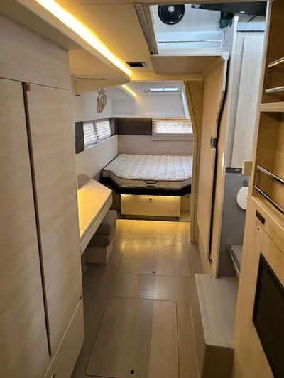 About Time Yacht Photos Pics Interior of a 2021 Leopard 45 catamaran with modern wood finish and cozy sleeping area.