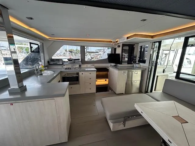 About Time Yacht Photos Pics Modern interior of a 2021 Leopard 45 yacht with sleek kitchen and dining area.