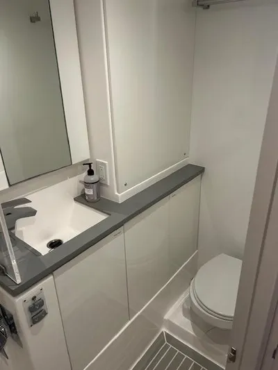 About Time Yacht Photos Pics Modern bathroom in a 2021 Leopard 45 yacht, featuring sleek sink and toilet design.