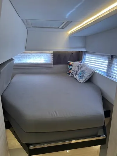 About Time Yacht Photos Pics Modern bedroom interior on 2021 Leopard 45 yacht with cozy bed and ambient lighting.