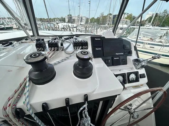 About Time Yacht Photos Pics Helm of 2021 Leopard 45 catamaran with navigation equipment and winches in marina setting.