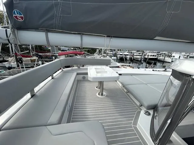 About Time Yacht Photos Pics Leopard 45 catamaran deck with seating and table, docked at marina, 2021 model.