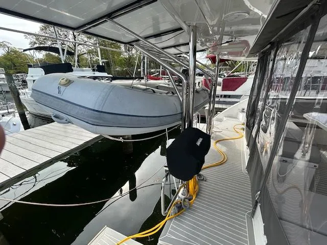 About Time Yacht Photos Pics 2021 Leopard 45 yacht with dinghy on deck, docked at marina.